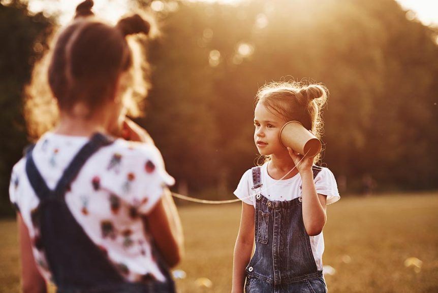 two-female-kids-stands-in-the-field-and-talking